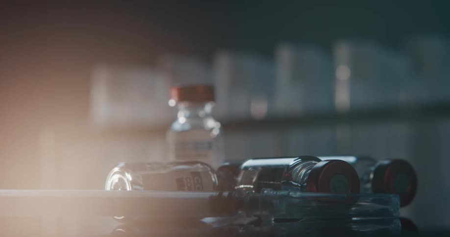 Vaccine bottles and syringe spinning inside a laboratory