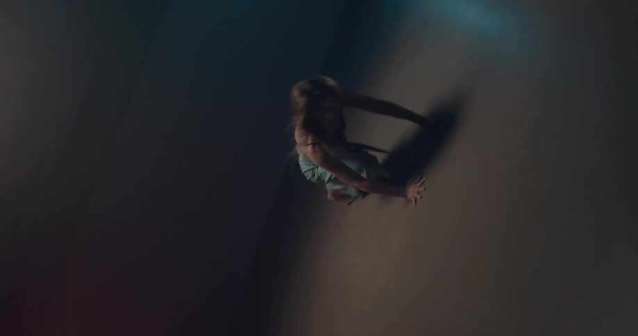 White woman dancing alone in the middle of a dark room