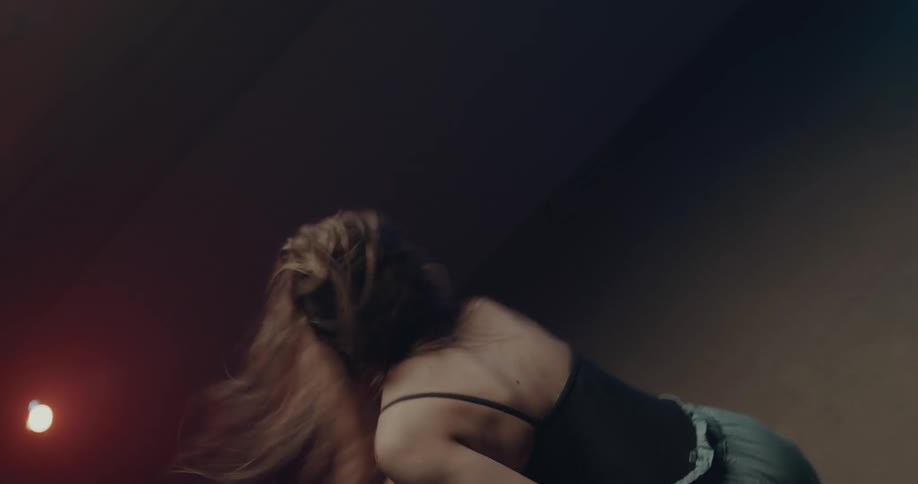 A woman is dancing in the dark room