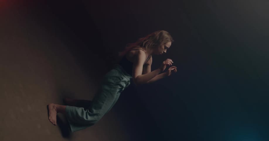 A woman performs a dance routine on stage with spotlights