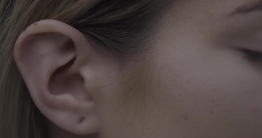 A womans ear with her eyes closed