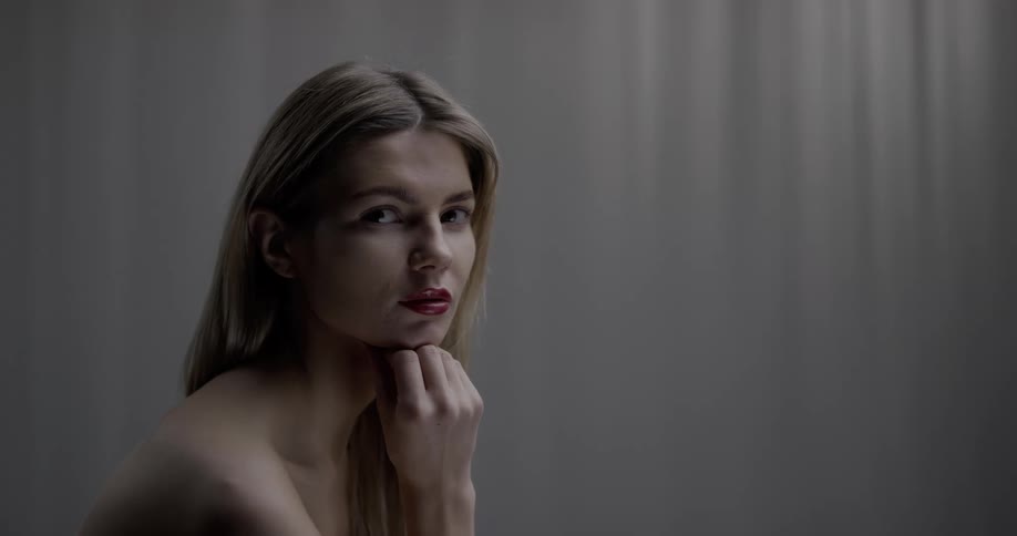 A woman with lipstick in a room staring