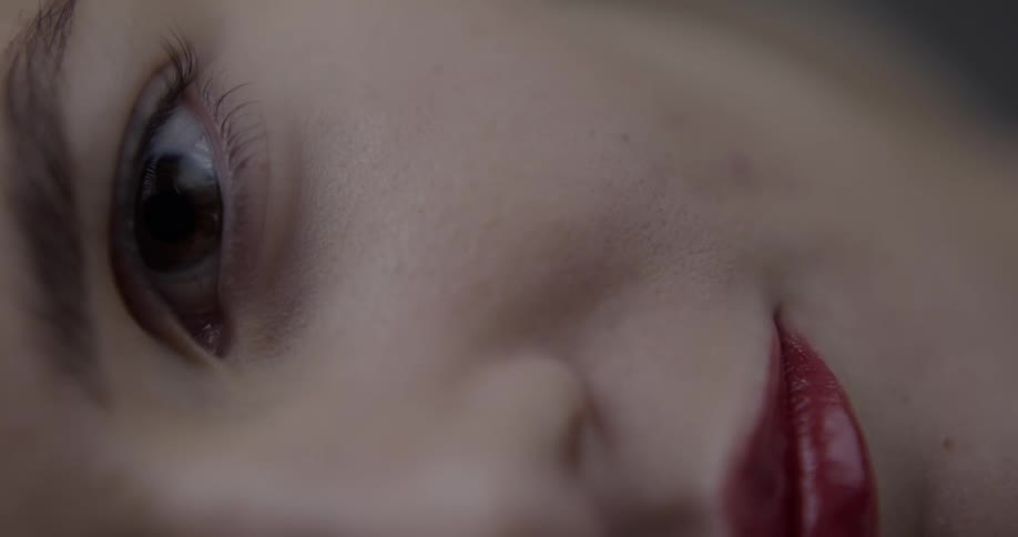 Woman wearing red lipstick opens her eyes
