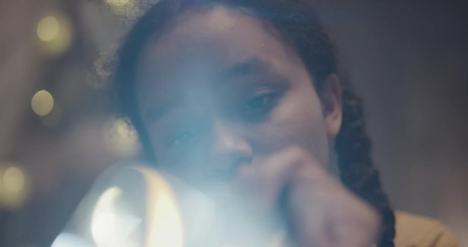 A girl in a room shining a flashlight through a crystal