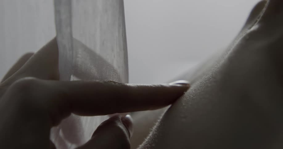 A womans hand touching fabric and her body