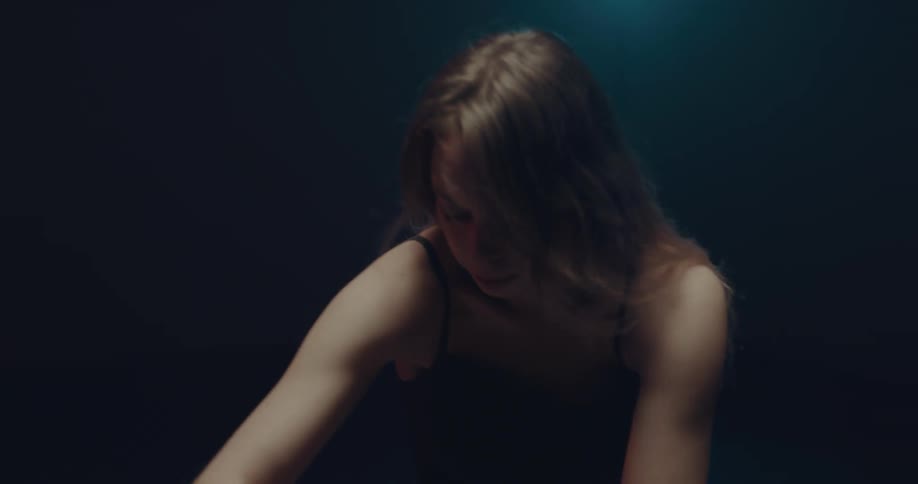 A woman is dancing by herself with a spotlight