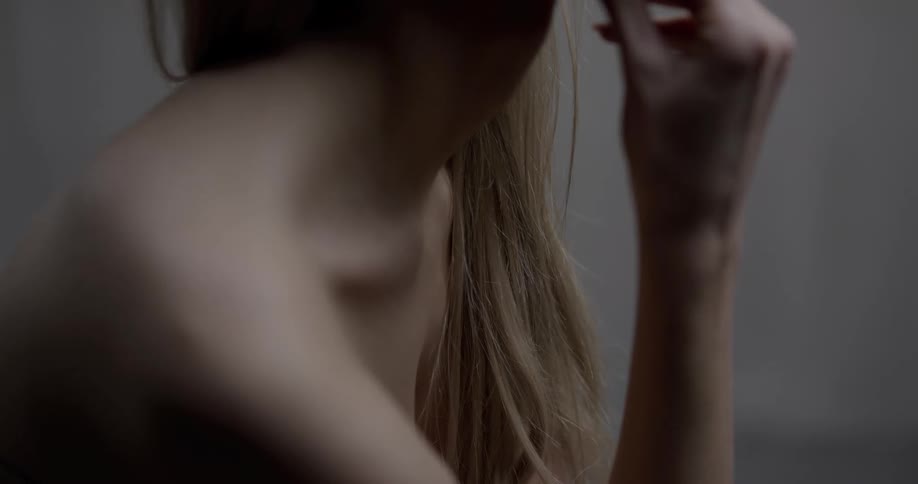 Woman sitting in the nude looking off to her side