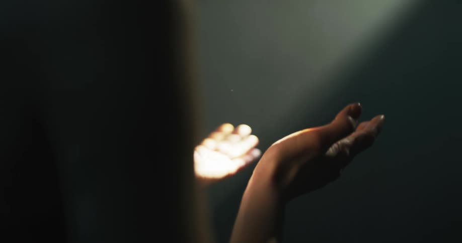 A woman moves her hands under the light