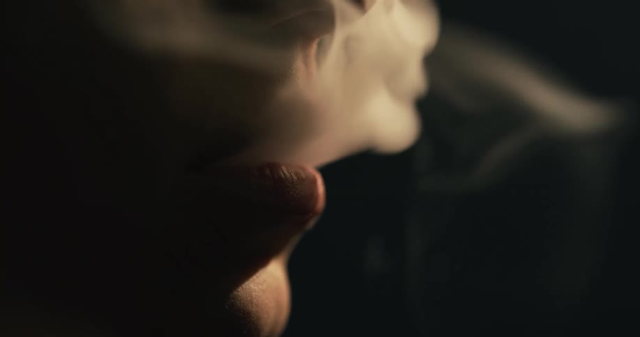 A man releasing smoke from his mouth