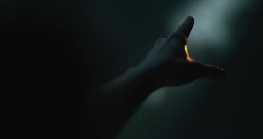 A person in a room holding out their hand on a sunbeam