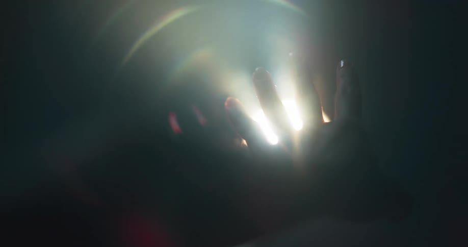 A person has their hand next to a light fixture