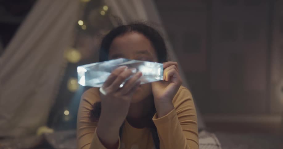 A girl is shining a flashlight on a piece of crystal