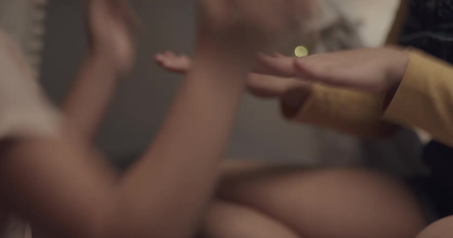 A girl is playing a game with hers and another persons hands