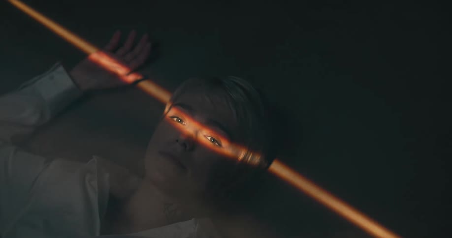 A woman laying on a floor with a light going across the eyes