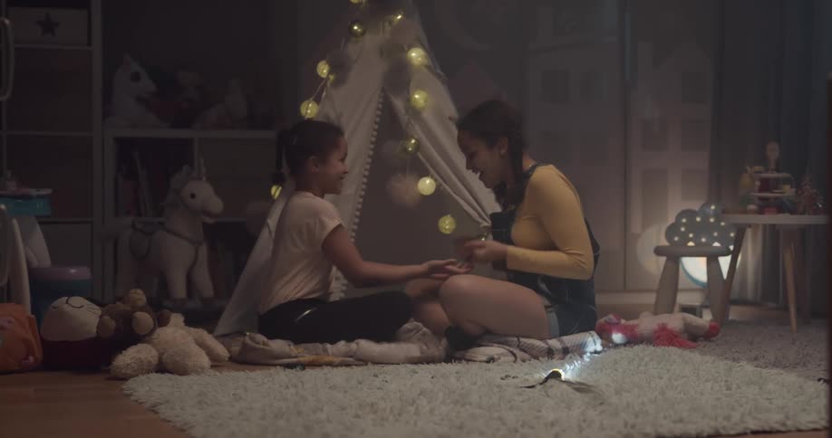 Two sisters are playing in their room together