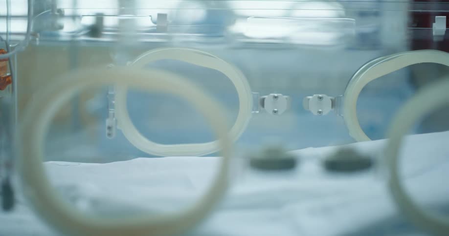 An empty baby incubator in a hospital room during the day
