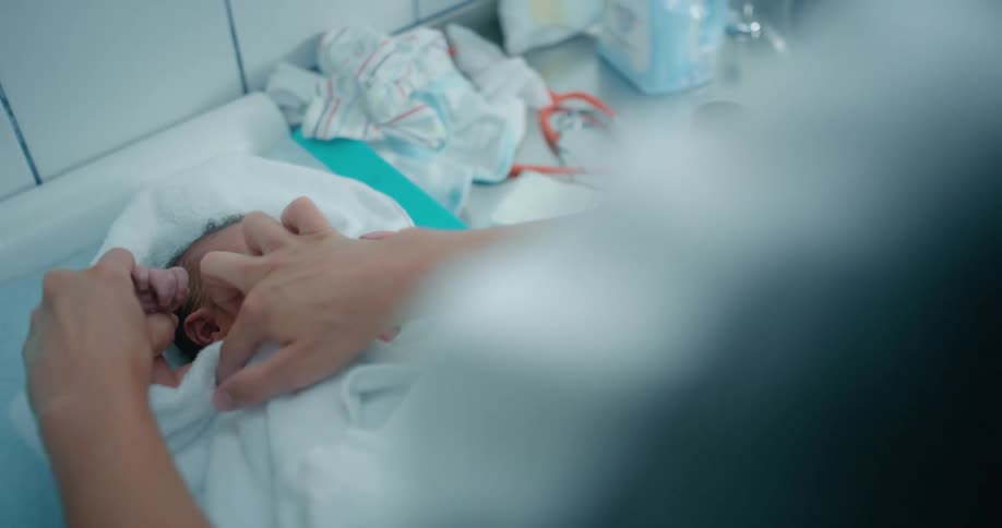 Newborn baby being treated by a nurse in a hospital