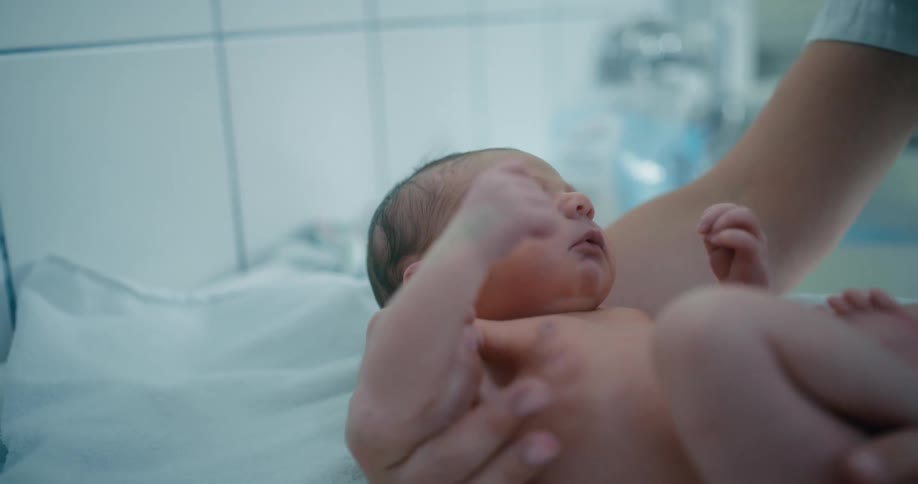 Newborn baby being treated in a hospital room