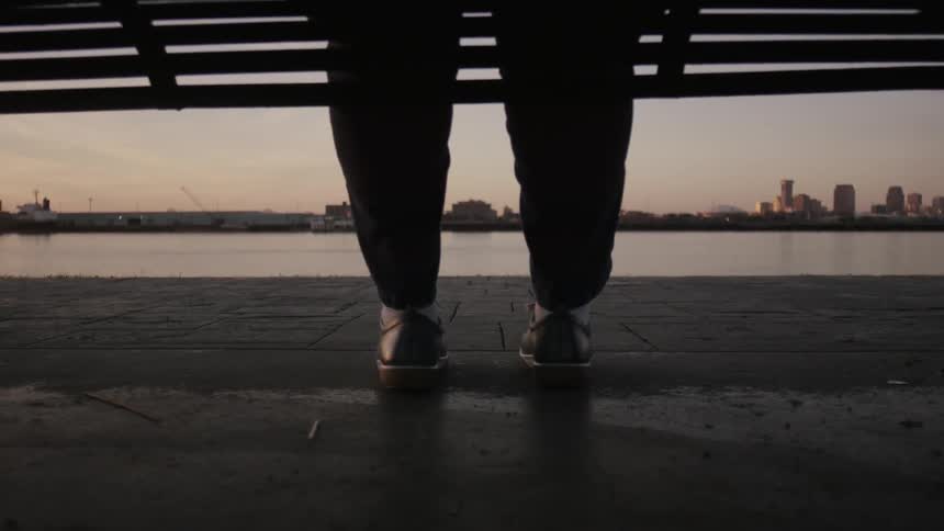 Close up of someone's legs as they sit on a bench