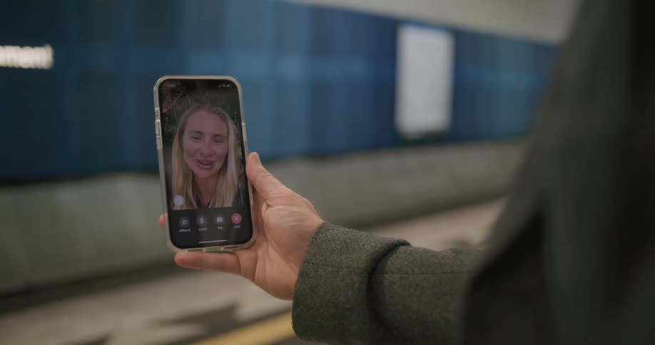 A person holding a cellphone while in a video call with a blonde woman