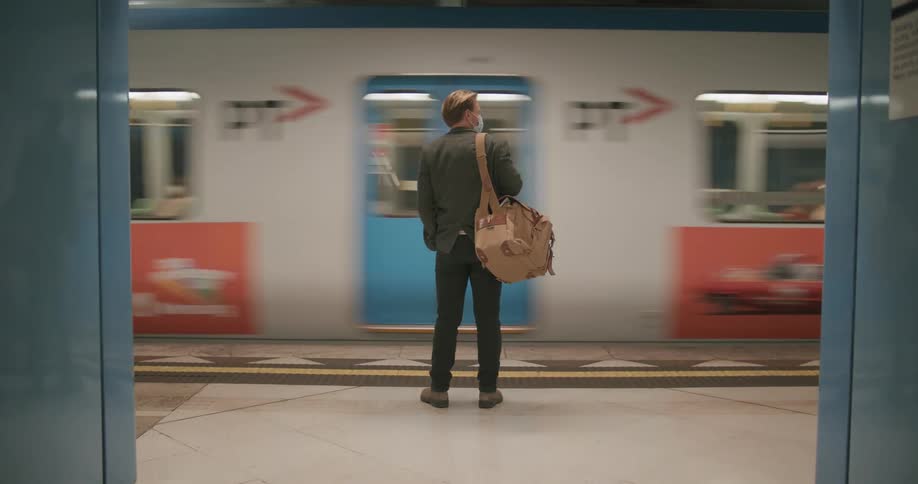 Man standing on a metro station waiting for the train stops
