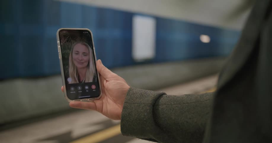 A woman holds a cell phone as she video chats with another woman on it