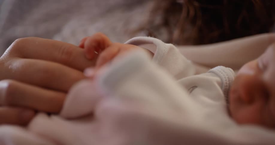 Mother holding newborn baby on her arms at home