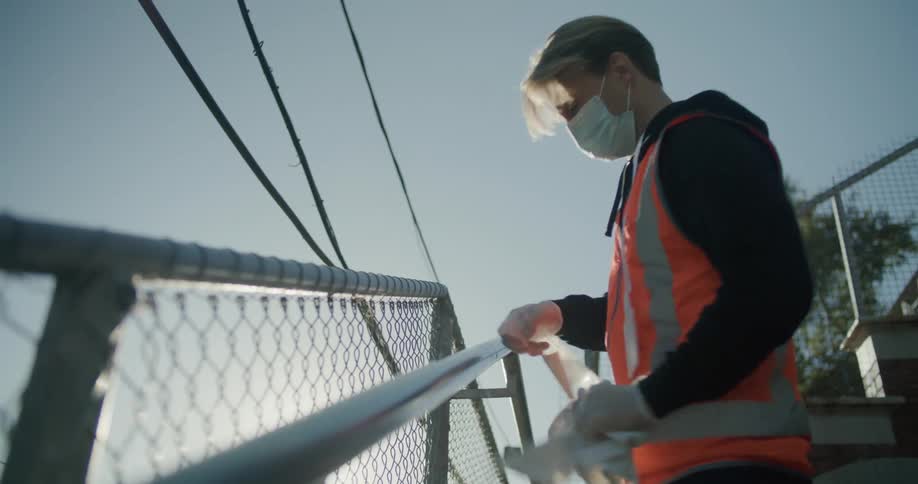 Working man disinfecting and cleaning a handrail