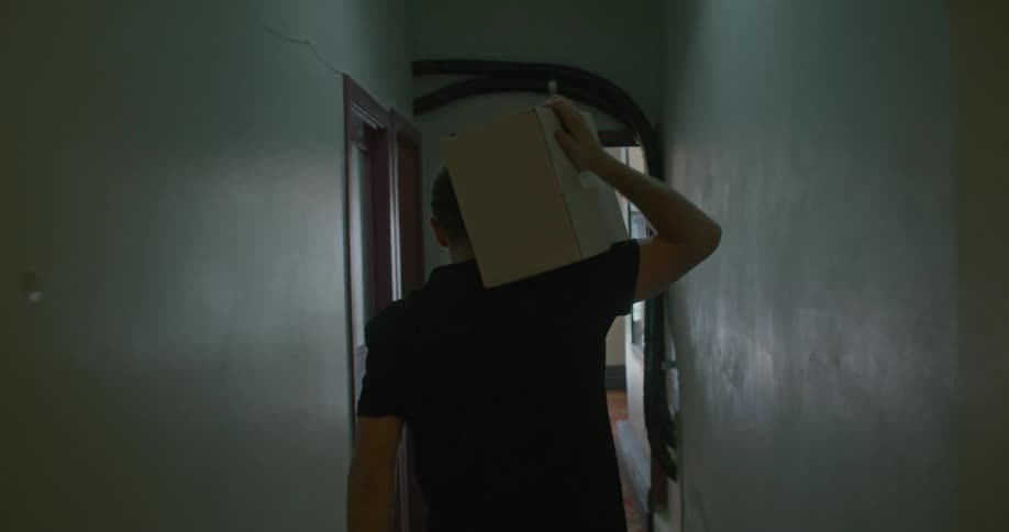 Man carrying a carboard box out of a building