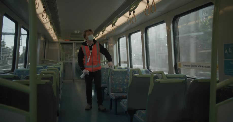 White man working inside a train by cleaning up and disinfecting the seats