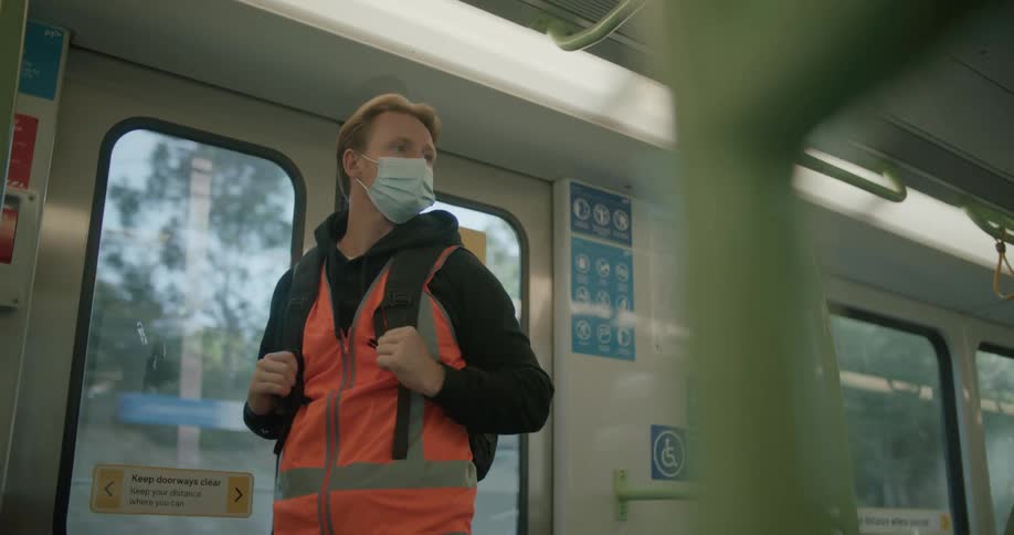A man with a mask riding public transit