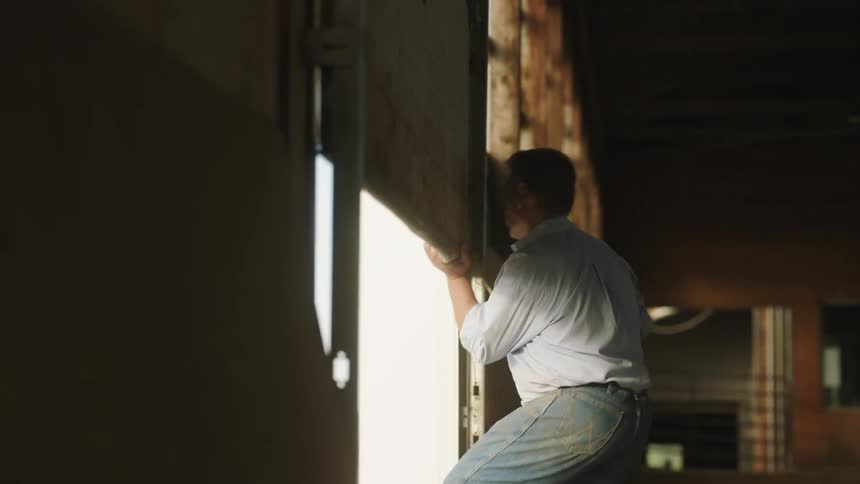 A man opening a barn door