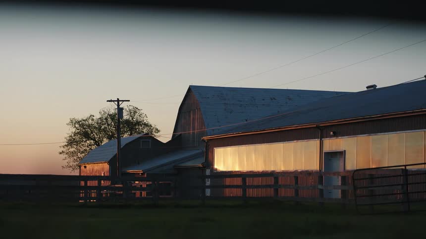 A barn house building in a rural area at sunrise