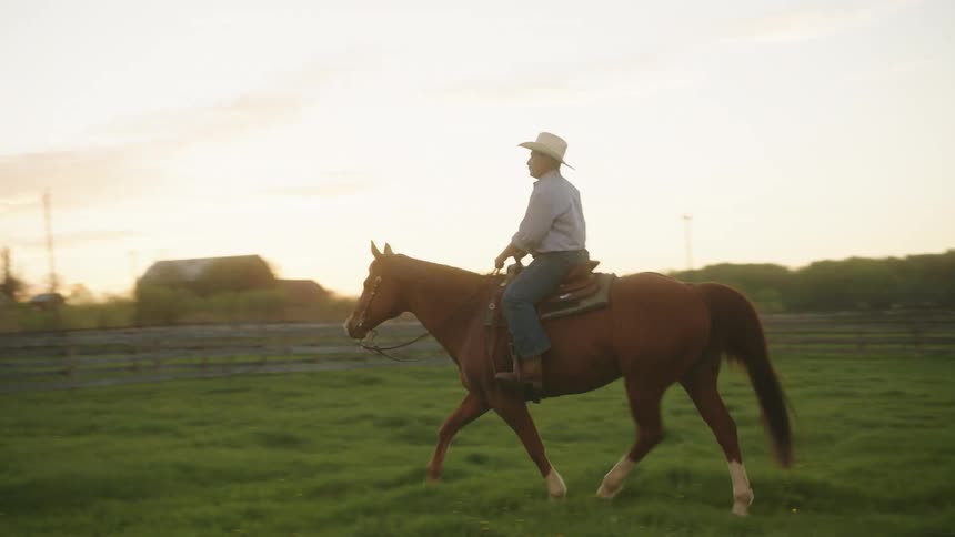 A man is riding his horse on the ranch
