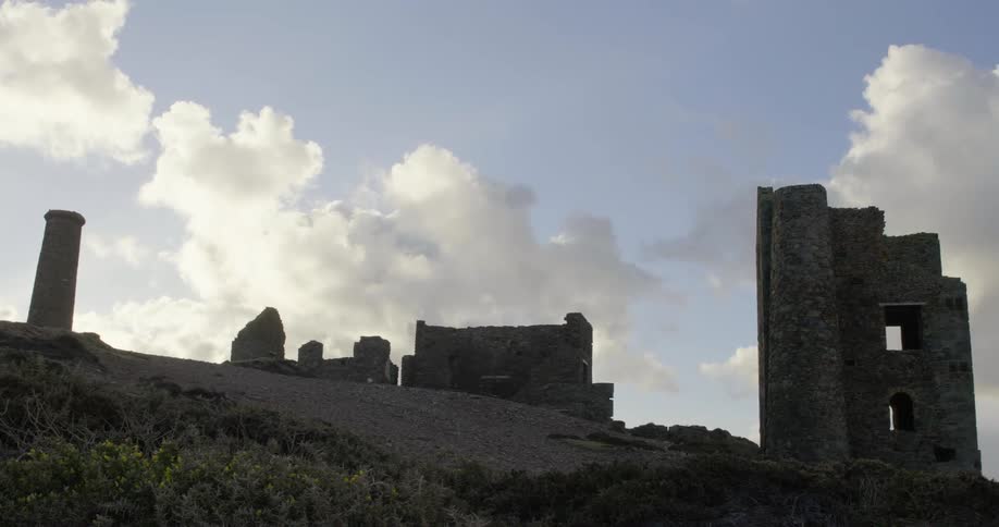 A hill with stone ruins with the sky and clouds in the background