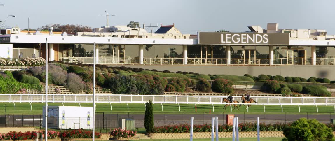 Horses are racing around the track