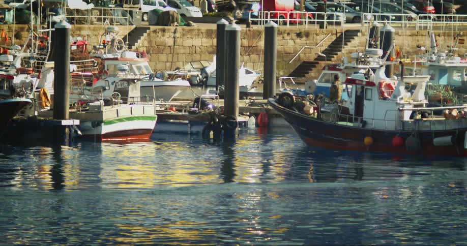Fishing boats arriving at the dock neaar the town at daytime