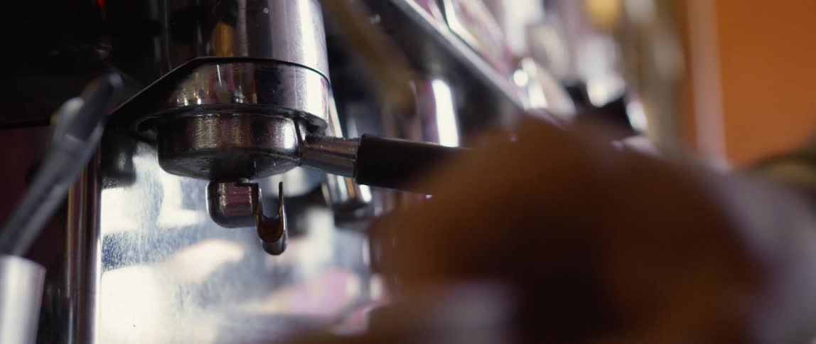 A male employee prepares coffee at a shop