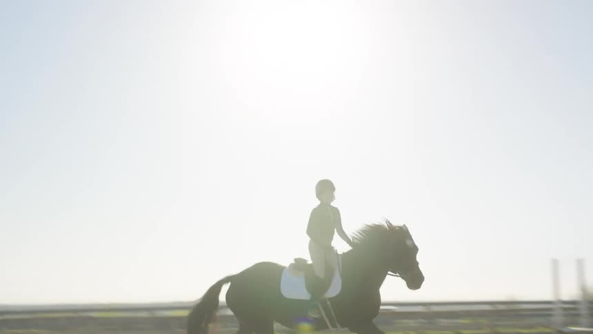 A man trains a girl on equestrianism inside a corral in a ranch