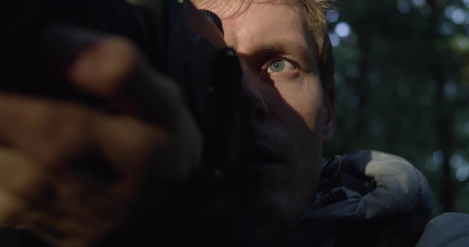 A professional photographer is holding a camera with sunlight hitting his face