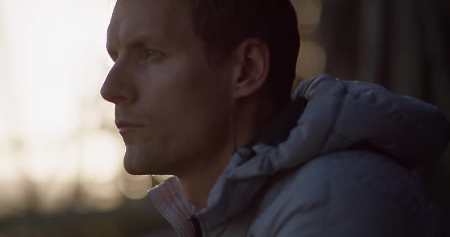 A man gazes into the horizon while sitting during a sunset