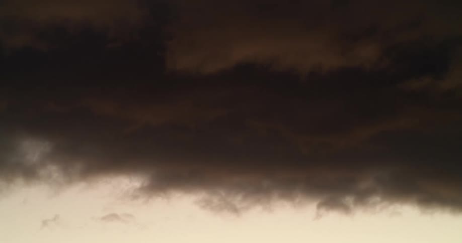 Thick red storm clouds move in the sky at dusk