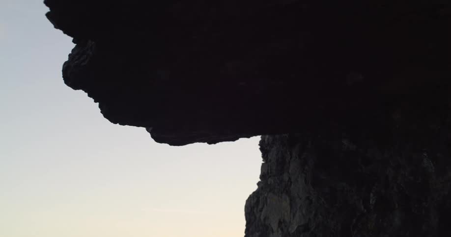 Coastal area with jagged rocks and a cliff at dawn