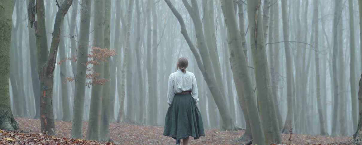 A woman is walking in a forest in autumn