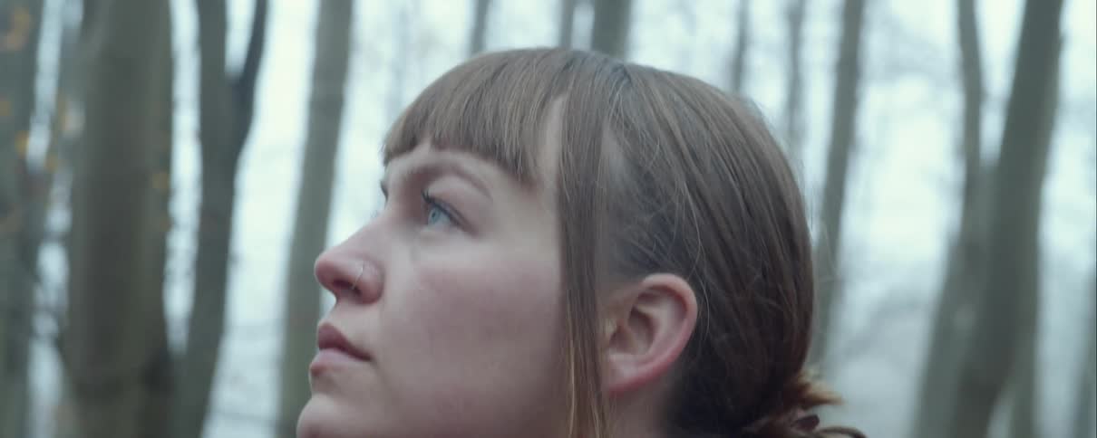 A young woman looking around in a forest