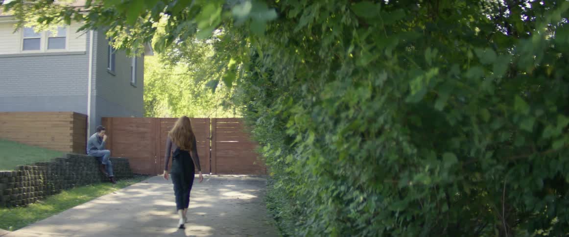 A woman walks down the driveway