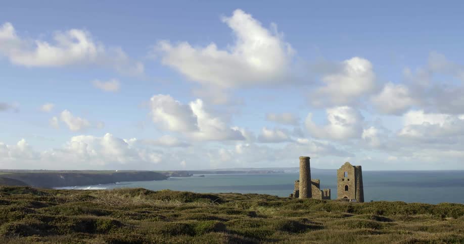A coast with stone ruins with the ocean sky and clouds in the background