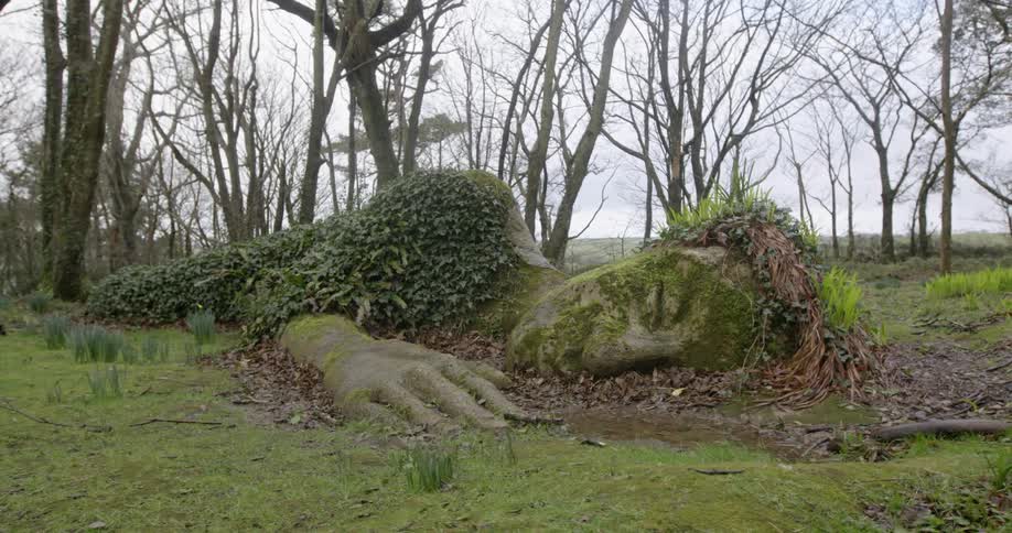 The giant statue laying on the green grass