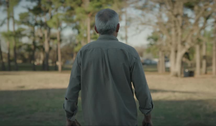 Senior citizen comes out of a house to plant seeds on the yard