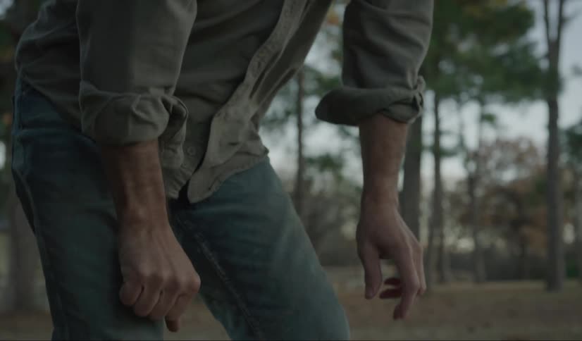 A elderly man crouching on the ground looking sad and then gets up and walks away